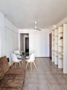 a living room with a glass table and white chairs at Departamento en barrio Martin in Rosario