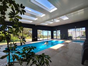 a swimming pool in a house with a ceiling with skylights at La Bonita Suites Punta Colorada in Punta Colorada