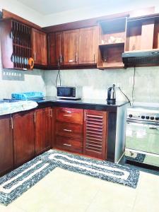 a kitchen with wooden cabinets and a microwave at Traveller's casa closer to highway in Homagama