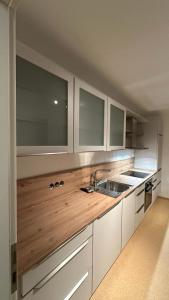 a kitchen with white cabinets and a sink at Stadtwohnung in Oldenburg