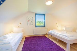 ゼリンにあるFerienhaus Wilde Wieseの紫色の敷物が敷かれた部屋のベッド2台