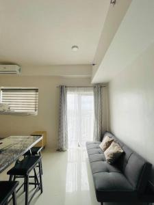 ein Wohnzimmer mit einem Sofa vor einem Fenster in der Unterkunft * * WV 2 Tranquil Haven in Iloilo City