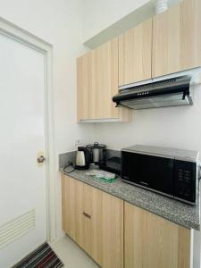 una cucina con forno a microonde e piano di lavoro di * * WV 2 Tranquil Haven a Città di Iloilo 1 altra foto