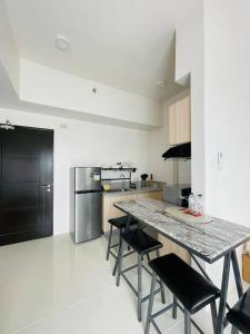 una cucina con tavolo e alcune sedie nere di * * WV 2 Tranquil Haven a Città di Iloilo