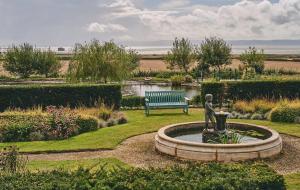 a fountain in a park with a bench and a statue at Aspen Suite in Barry