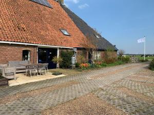 a brick house with a patio and a table at Bed and Breakfast de Salix in Hitzum