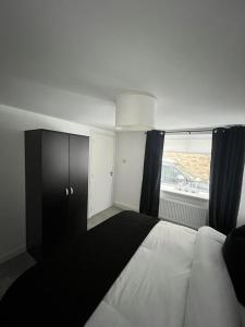 a bedroom with a bed with black curtains and a window at The Harbour Cottage in Peterhead