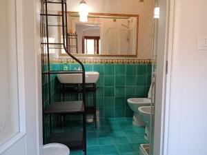 uma casa de banho verde com um lavatório e um espelho em Creta Rossa em Larino