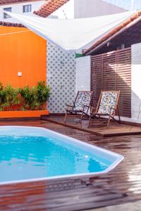 2 chaises et une piscine sur une terrasse dans l'établissement Valencia Hotel Natal, à Natal