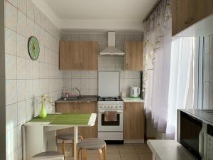 a small kitchen with a stove and a table at Уютные апартаменты недалеко от вокзала in Kyiv