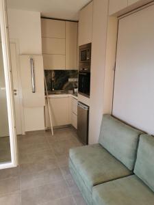 ein Wohnzimmer mit einem Sofa und einer Küche in der Unterkunft dreamy loft at 10th floor in Thessaloniki