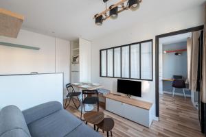 a living room with a couch and a desk with a tv at Stunning 1-bedroom apartment in a vibrant neighborhood of Montmartre in Paris