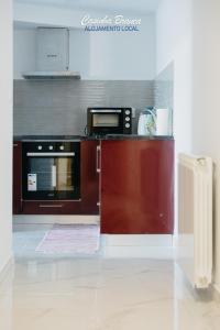 a kitchen with a stove and a microwave at Casinha Branca in Fundão