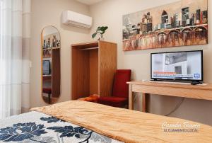 a bedroom with a bed and a desk with a television at Casinha Branca in Fundão