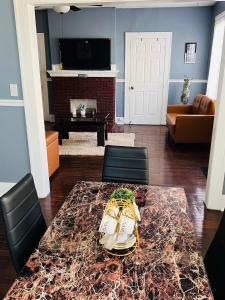 sala de estar con mesa, sillas y TV en Cozy Room in Private Home, en Irvington