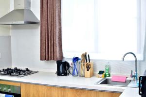 a kitchen counter with a stove and a sink at Kandiz Exquisite in Nairobi