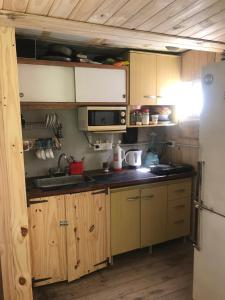 uma cozinha com armários de madeira, um lavatório e um frigorífico em Isla Curubica em Tigre