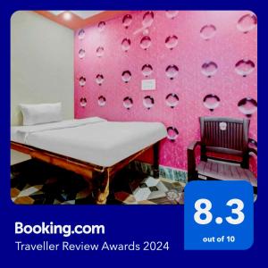 密拉特的住宿－OYO Sea Heaven Baraut，卧室设有粉红色的墙壁、一张床和一把椅子
