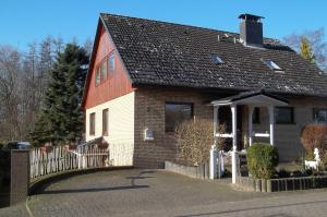 a red and white house with a fence at Ferienwohnung Batram 