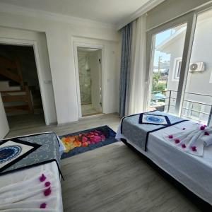 2 camas en una habitación con ventana grande en Villa Can Fethiye, en Fethiye