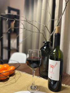 a bottle of wine next to a glass of red wine at New Charm Apartments near Border in Narva