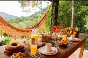 a table with food and orange juice on it at Refúgio Farm House in Paraty