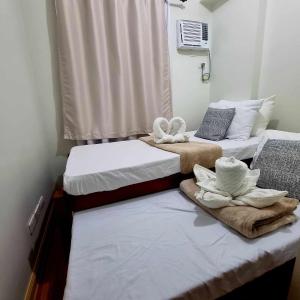 duas camas sentadas uma ao lado da outra num quarto em 2BR Condo Unit with Washer, INET, Desk Space, ground floor em Davao