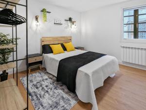 a bedroom with a bed with yellow pillows on it at Pedra Nova - Céntrico, Lujoso in Pontevedra