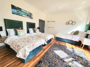 a bedroom with two beds and a rug at Sensational Room Stays- Callcott Road in London