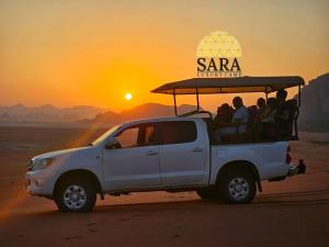 a white truck with a group of people in the back at SARA LUXURY RUM CAMp in Wadi Rum