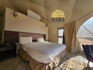 una camera con un grande letto in una tenda di SARA LUXURY RUM CAMp a Wadi Rum