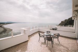 a balcony with a table and chairs and the ocean at Mona in Ulcinj