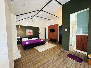 a bedroom with a purple bed and a bathroom at Western Ghats Holiday Home in Kalpetta