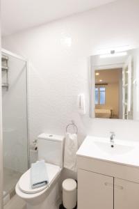 La salle de bains blanche est pourvue de toilettes et d'un lavabo. dans l'établissement Faro Downtown Ria Formosa Studios, à Faro