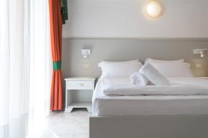 una camera con letto bianco e comodino bianco di Hotel Garda Bellevue a Limone sul Garda
