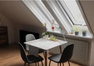 einen weißen Tisch und Stühle in einem Zimmer mit Fenster in der Unterkunft Galeriehaus in Münnerstadt