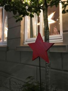 een rode ster op een paal voor een boom bij Ferienwohnung Schönwälder 