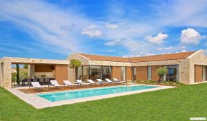 a villa with a swimming pool and lounge chairs at Terra Biancha in Brtonigla