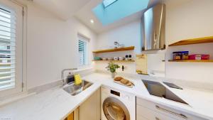 a kitchen with a sink and a washing machine at The Conifer Studio in Oxford