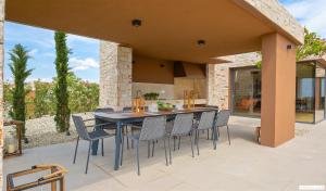 an outdoor dining area with a table and chairs at Terra Biancha in Brtonigla