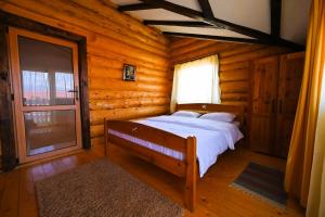Casa de Lemn في ريسنوف: غرفة نوم مع سرير في كابينة خشب