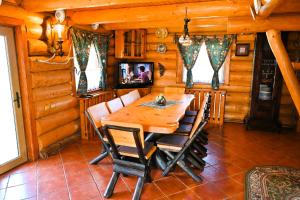 Casa de Lemn في ريسنوف: غرفة طعام مع طاولة وكراسي خشبية