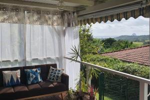 a couch sitting on a balcony with a view at Bungalow vue mer avec jardin in Sainte-Luce
