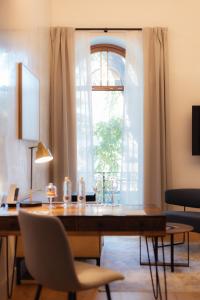 comedor con mesa y ventana en Cavalta Boutique Hotel GL en Sevilla