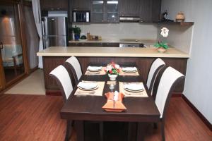 a kitchen with a wooden table with white chairs and a tableablish at Koh Chang Appartment 2 bedrooms in Ban Bang Bao