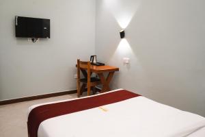 a bedroom with a bed and a desk with a television at Nexa Hotel in Arusha