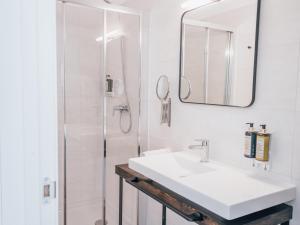 a white bathroom with a sink and a shower at Dear Faro - Guest House in Faro