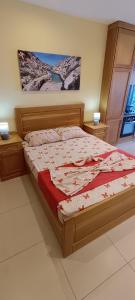 ein Bett in einem Schlafzimmer mit zwei Nachttischen und zwei Lampen in der Unterkunft Marsalforn Sea Front Studio in Żebbuġ