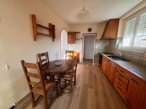 Il comprend une cuisine avec une table et des chaises en bois. dans l'établissement Maison au pied des Vignes, à Vosne-Romanée
