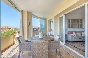 a living room with a table and chairs and a couch at modern apartment by the sea.(Marbella) in Marbella